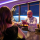 two people get handed drinks from a bartender at the immersive star wars bar on the disney wish